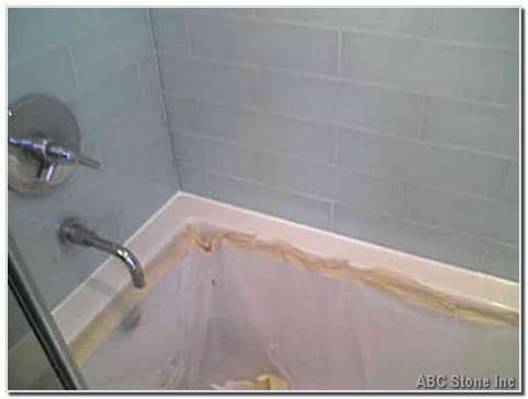 bathtub and white tile wall with new caulk applied