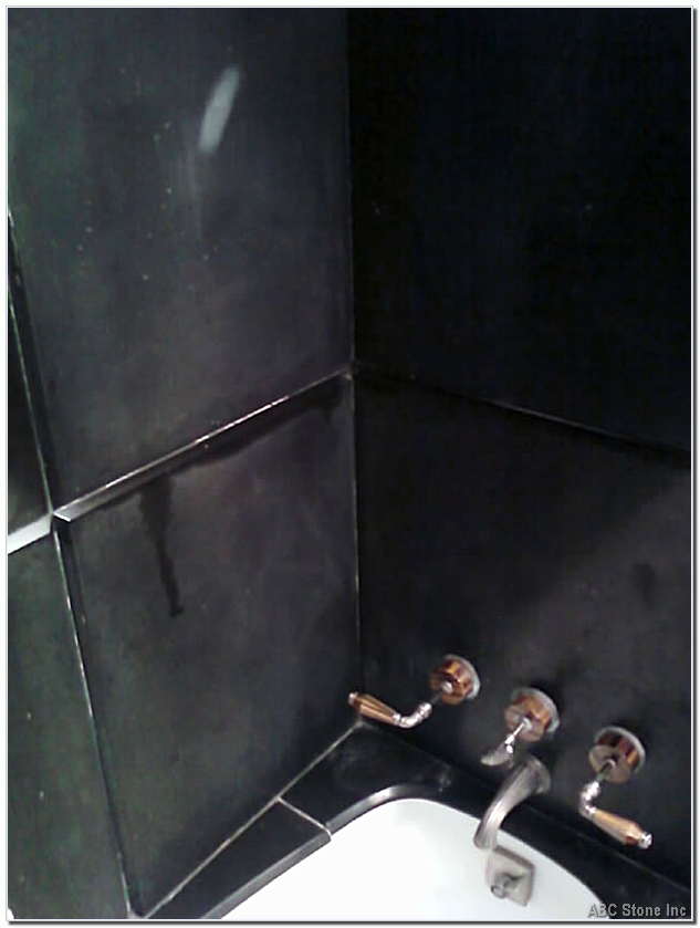 Black slatestone shower wall before renovation