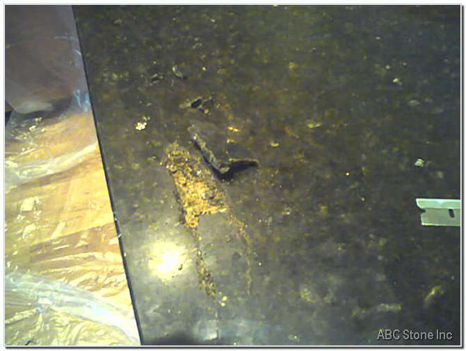 Close up view of granite surface with small chip before repair