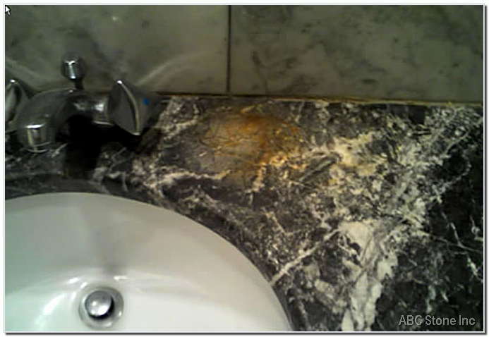 Stained marble bathroom vanity undergoing repairs before renovation